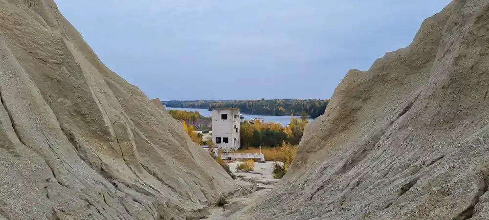 Abandoned concrete structure framed by steep sandy slopes