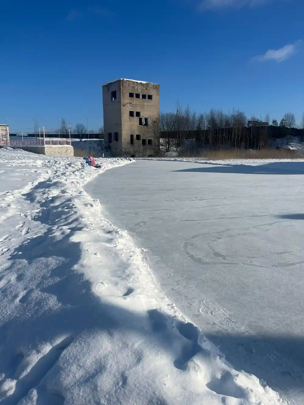 Abandoned concrete tower on frozen snowy lake