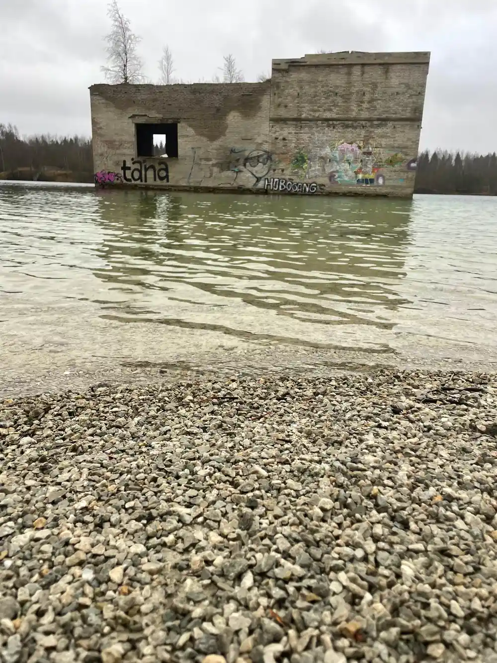 Concrete building ruin partially submerged in turquoise water
