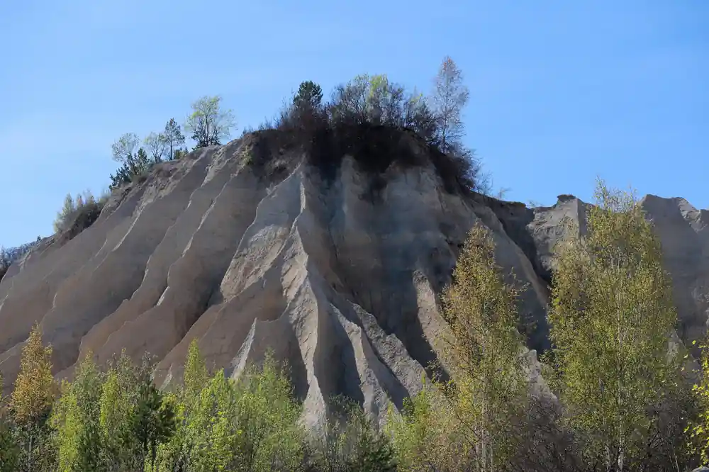 Large conical hill with erosion scars and sparse trees