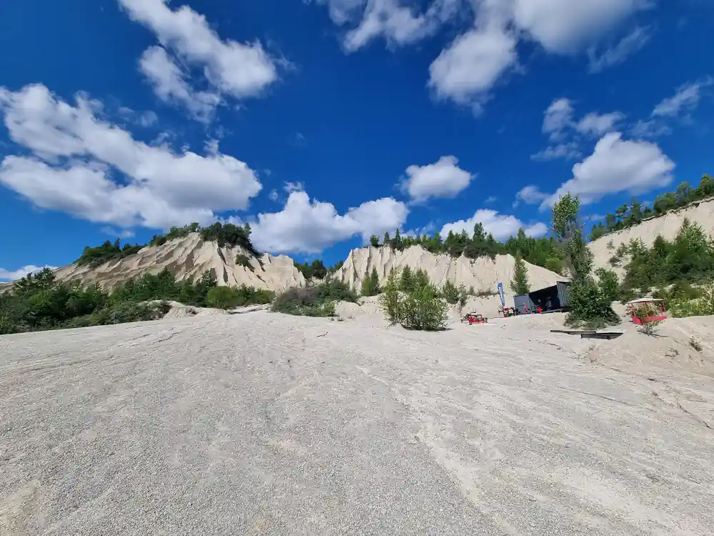 Large sand quarry with steep cliff faces and machinery