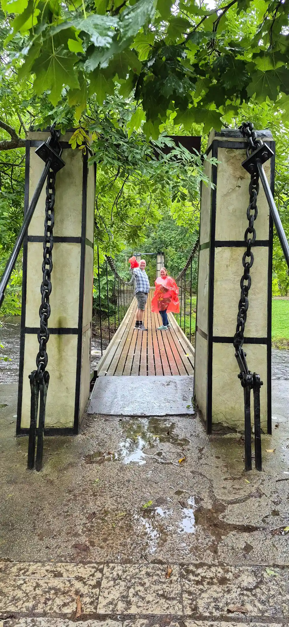 Metal gate with chain leading to wooden bridge
