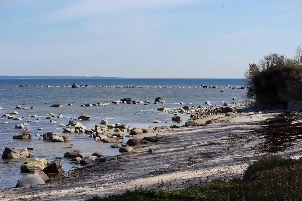 Rocky beach with scattered boulders meeting calm sea