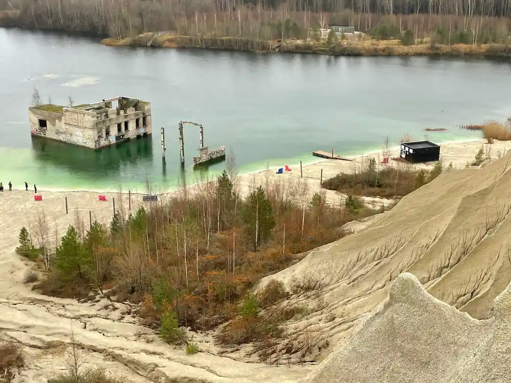 Ruined concrete building in turquoise water with sandy beach