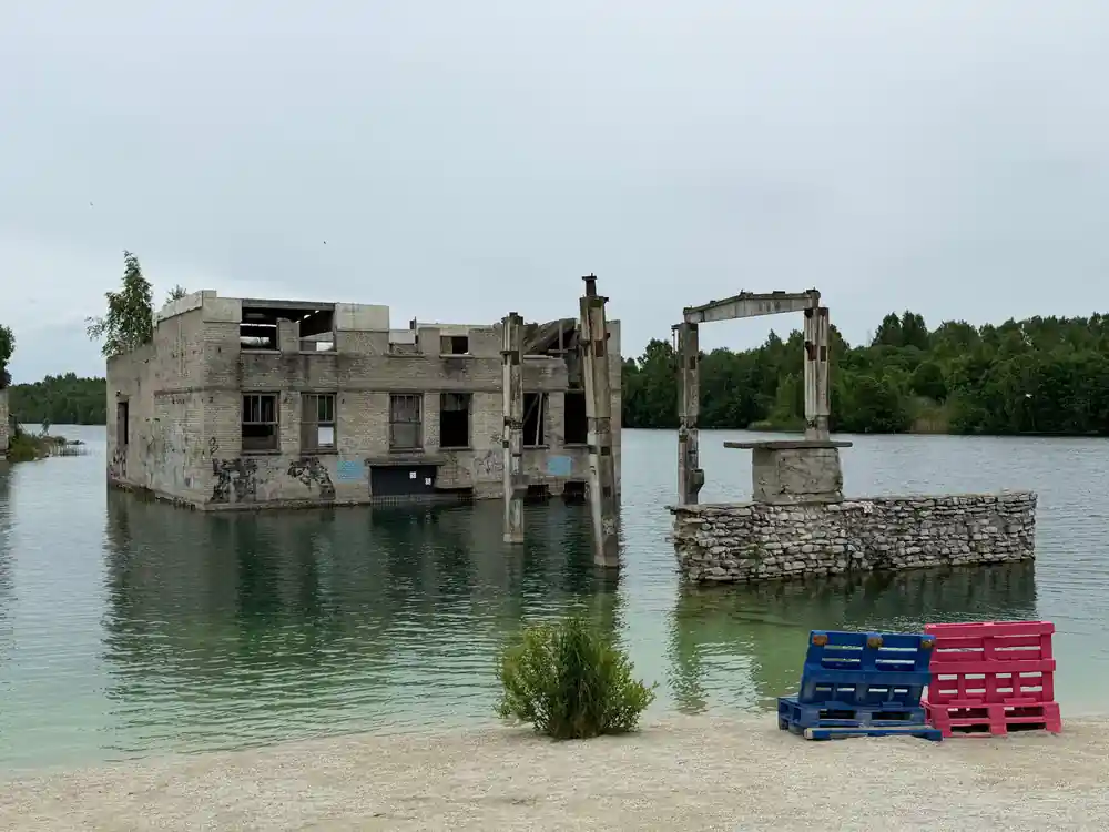 Ruined concrete buildings in water with crates