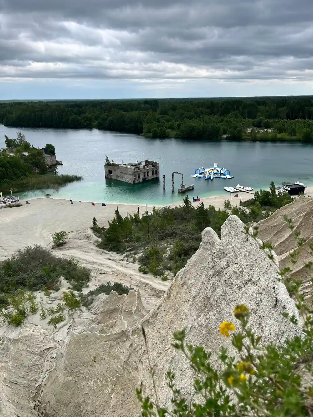 Ruined stone fort in water with turquoise beach and quarry
