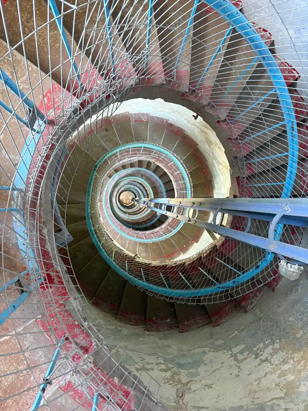 Spiral staircase viewed from above with colored ropes
