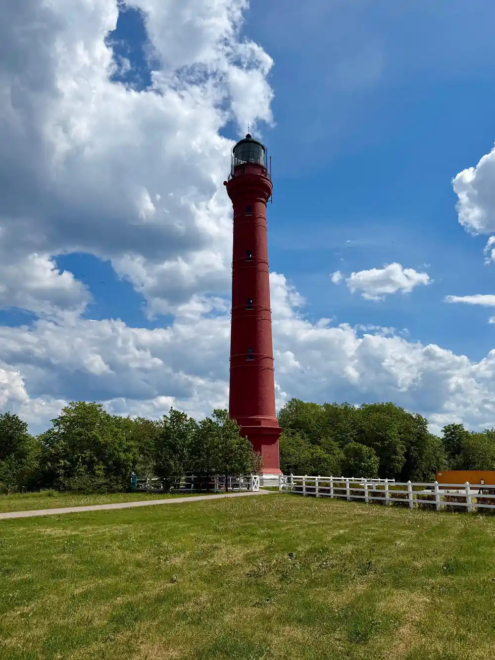 Tall red lighthouse against blue sky
