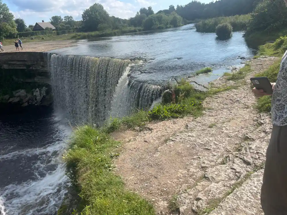 Waterfall with sandy beach and river landscape